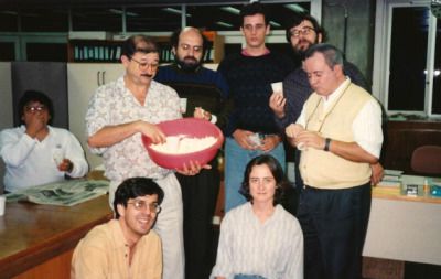 The FAPESP team working in the office in 1994. There are 7 men and 1 woman posing for the photo. Demi Getschko is in the back of the photo in glasses and a dark sweater.