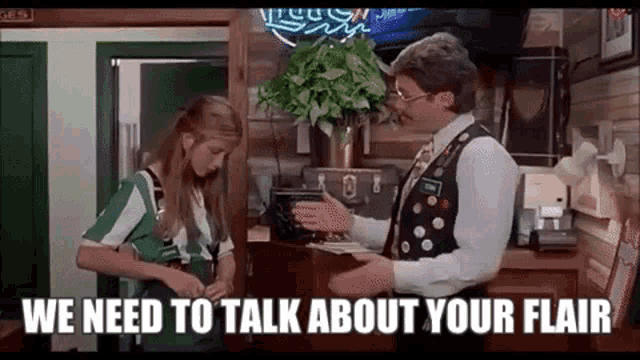 A male restaurant manager lecturing a female employee for not wearing enough pins on her uniform, in the movie Office Space